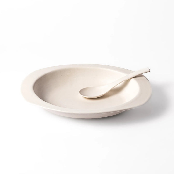 White oval ceramic curry plate with a wide rim and curved sides, designed for smooth scooping and serving of curry, rice, or pasta dishes.