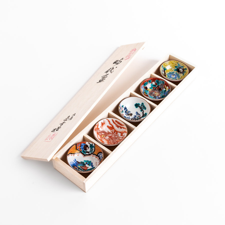 Elegant set of five sake cups with intricate floral and traditional patterns, presented in a wooden box, showcasing timeless Japanese craftsmanship and design.