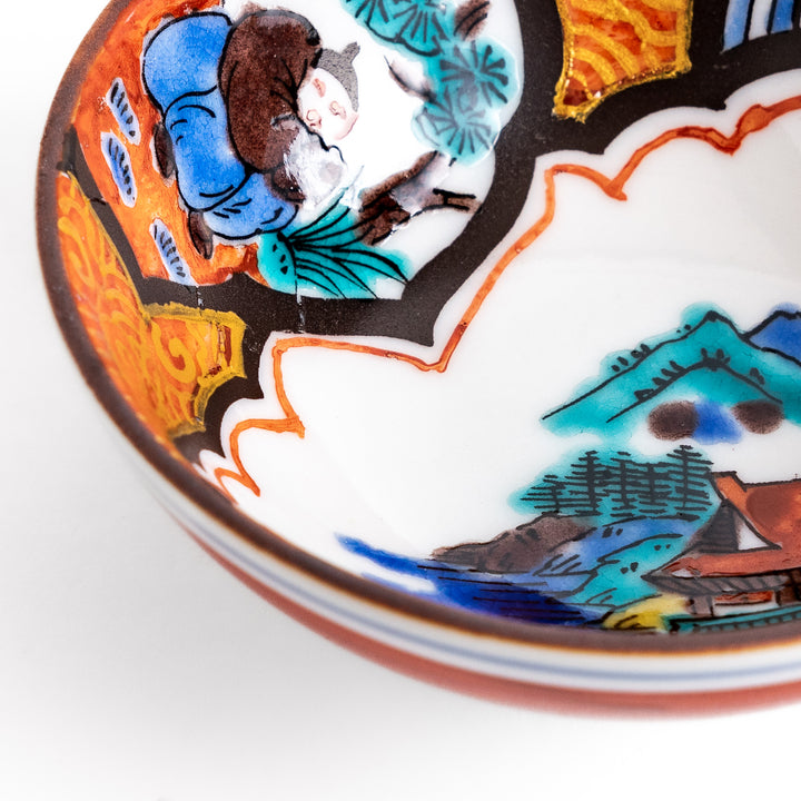 Traditional sake cup featuring a detailed design of a scenic mountain landscape, with vibrant colors and intricate patterns in blue, green, and orange.