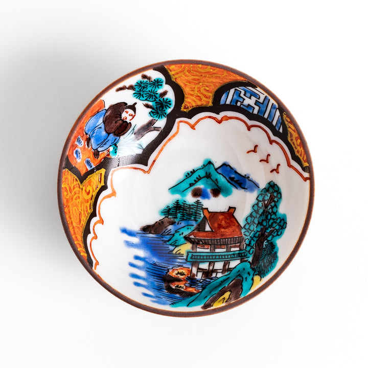 Traditional sake cup featuring a detailed design of a scenic mountain landscape, with vibrant colors and intricate patterns in blue, green, and orange.