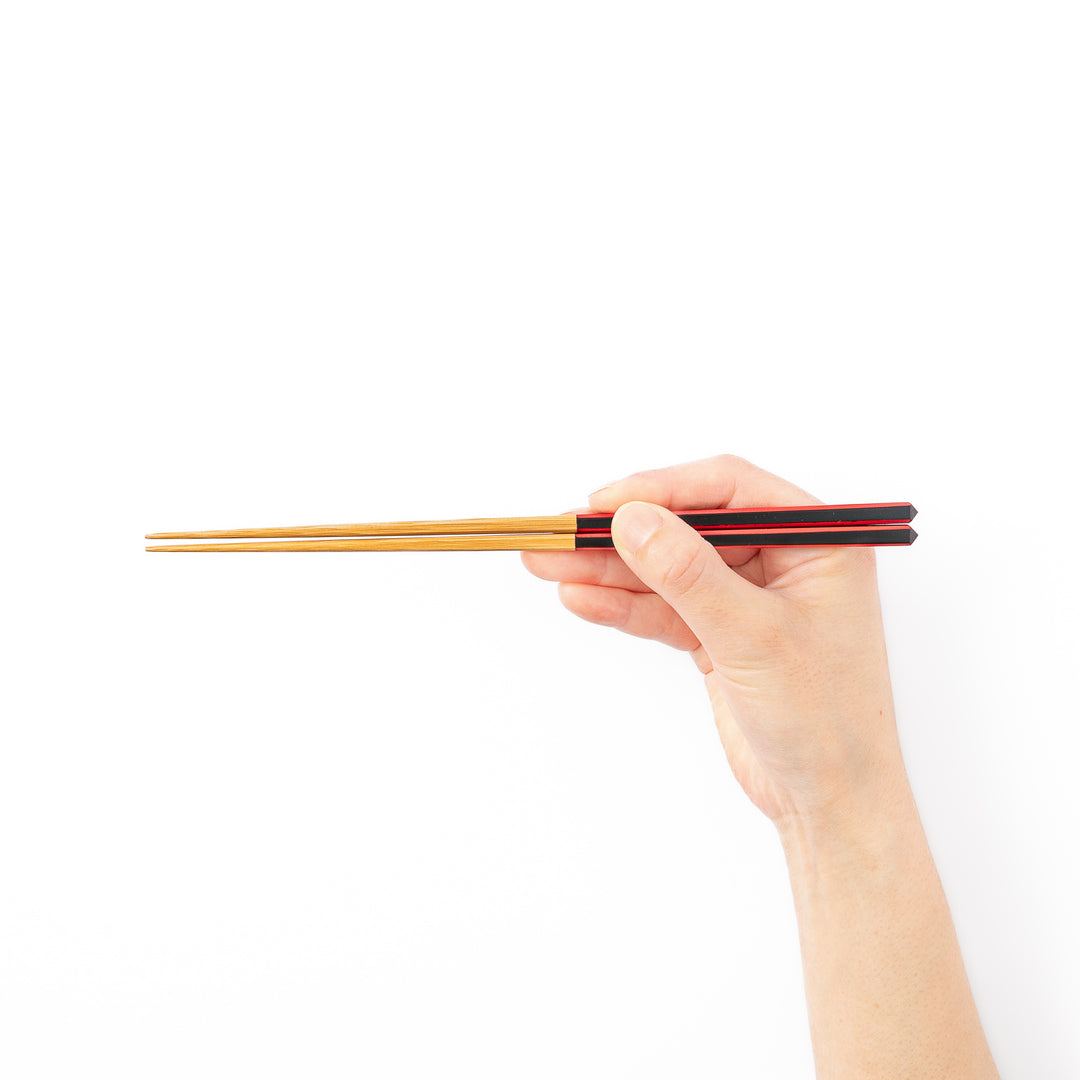 Fine tip Japanese bamboo chopsticks featuring a black handle with bold red side stripes and a natural bamboo finish