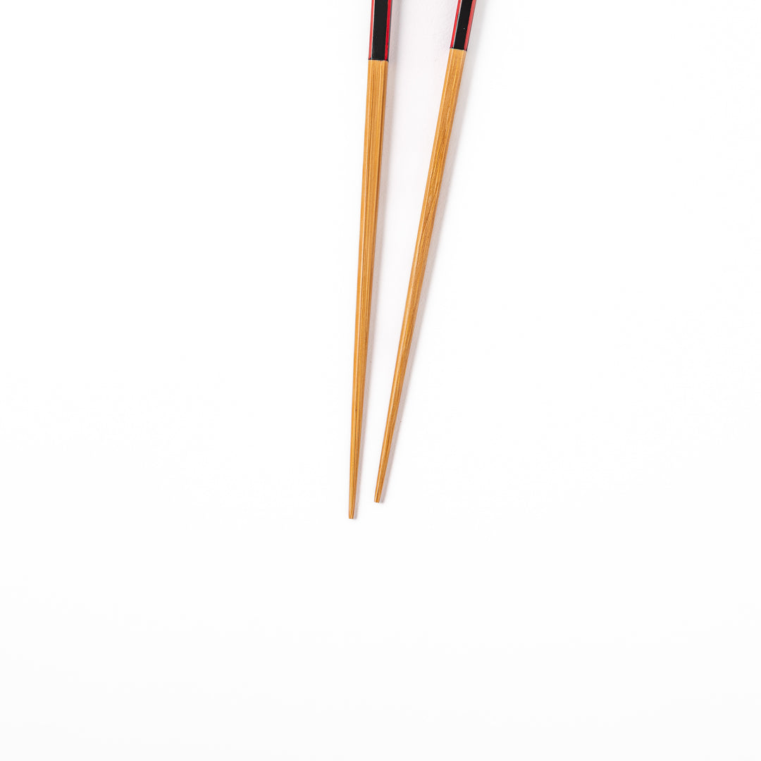 Fine tip Japanese bamboo chopsticks featuring a black handle with bold red side stripes and a natural bamboo finish