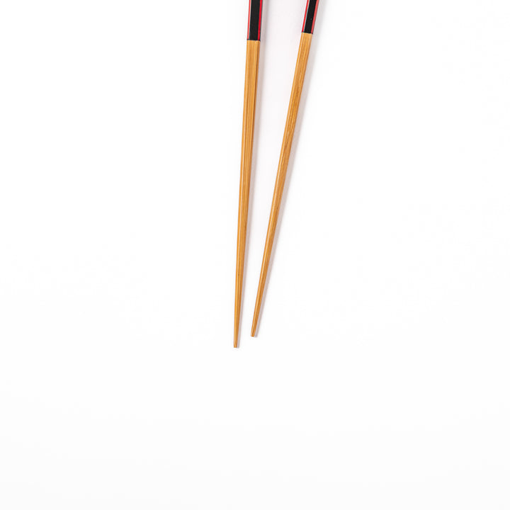 Fine tip Japanese bamboo chopsticks featuring a black handle with bold red side stripes and a natural bamboo finish