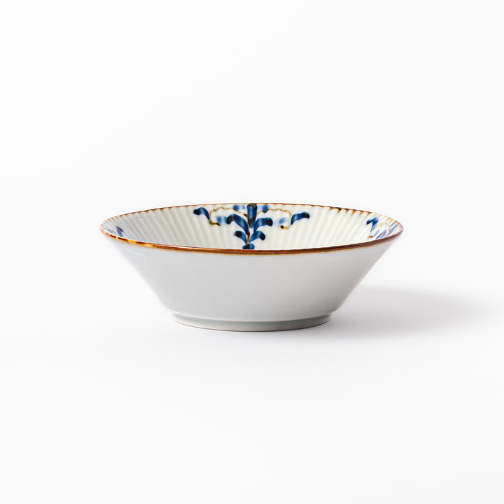 White dessert bowl with vertical ridges, blue floral accents around the rim, and a warm brown edge, perfect for sweets or fruit.