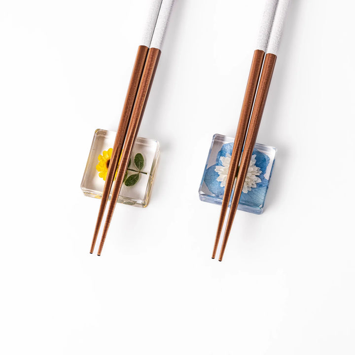 Floral-themed Japanese chopsticks gift set with pastel handles and clear rests featuring pressed sunflower and daisy.