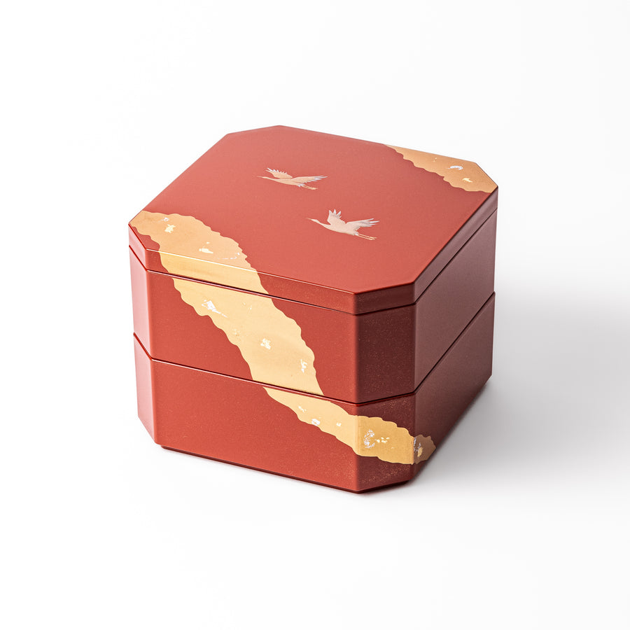 Gold River & Crane Japanese Jubako Box in hexagonal form with gold river and crane motif on vermilion red lacquer, perfect for festive food presentation.

