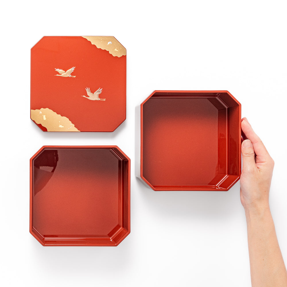 Gold River & Crane Japanese Jubako Box in hexagonal form with gold river and crane motif on vermilion red lacquer, perfect for festive food presentation.