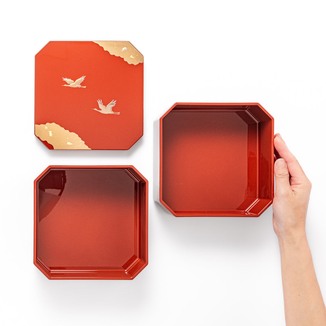 Gold River & Crane Japanese Jubako Box in hexagonal form with gold river and crane motif on vermilion red lacquer, perfect for festive food presentation.