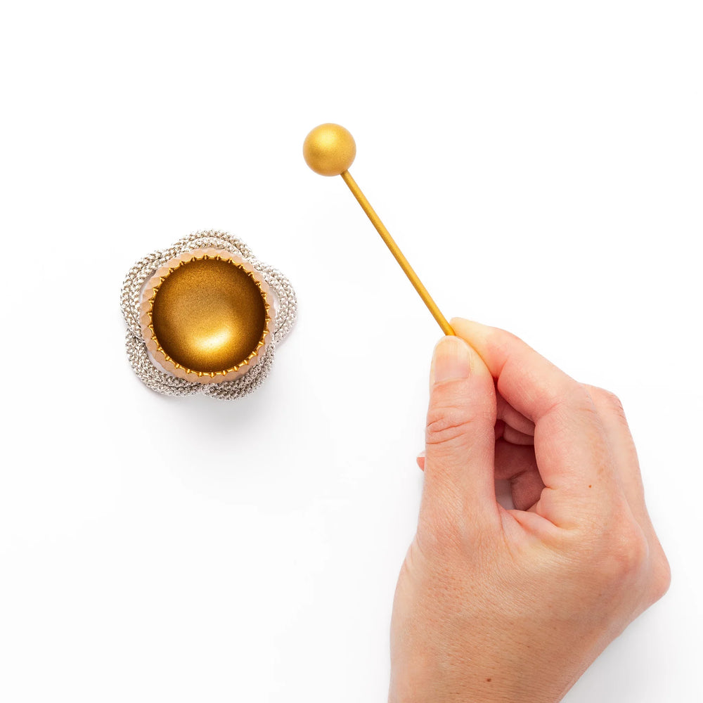 Golden Japanese brass meditation bowl striker with sleek handle and round base for prayer or rituals.