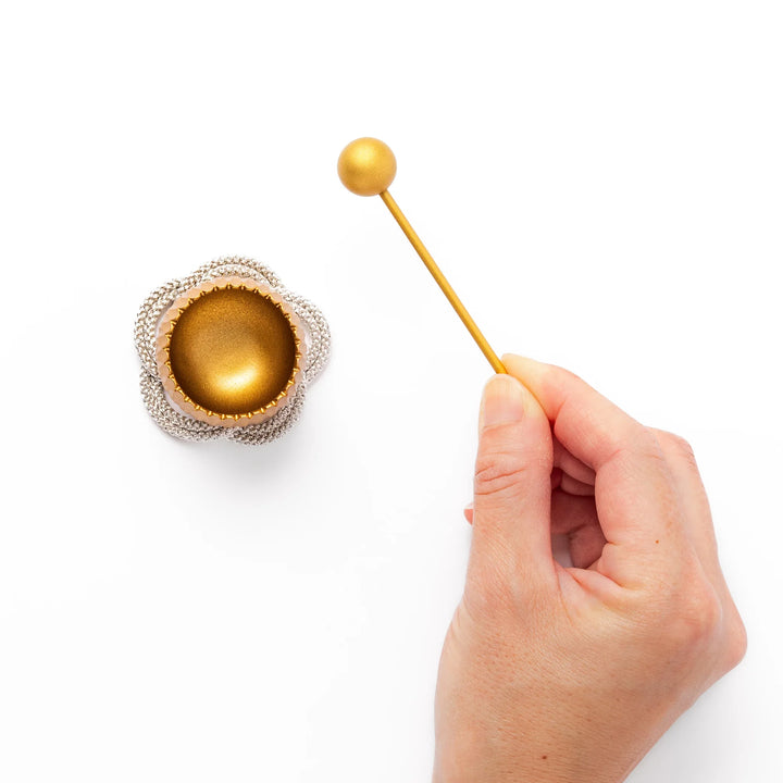 Golden Japanese brass meditation bowl striker with sleek handle and round base for prayer or rituals.