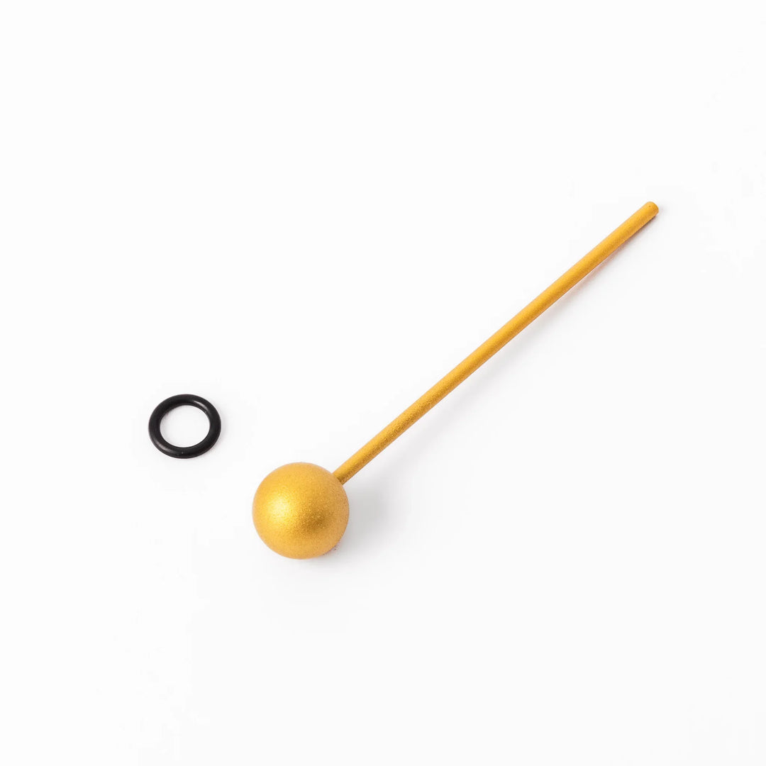 Golden Japanese brass meditation bowl striker with sleek handle and round base for prayer or rituals.