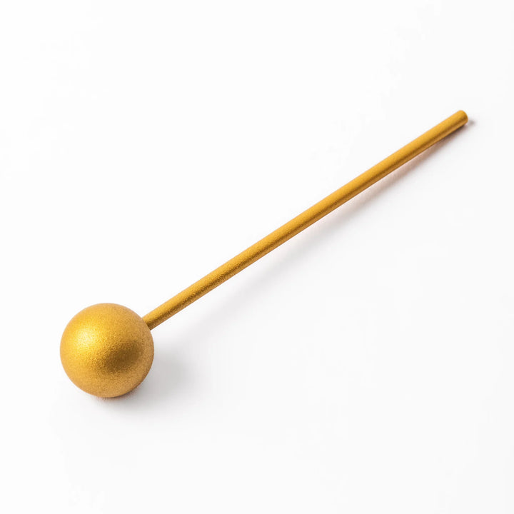 Golden Japanese brass meditation bowl striker with sleek handle and round base for prayer or rituals.