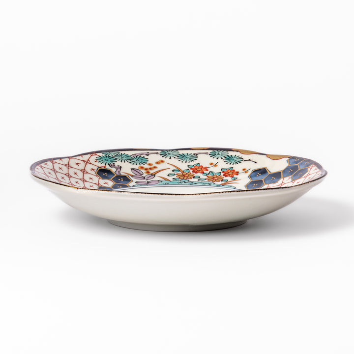 Scalloped Japanese dessert plate with red lattice, navy hexagons, and multicolor floral design, perfect for adding charm to elegant table settings.