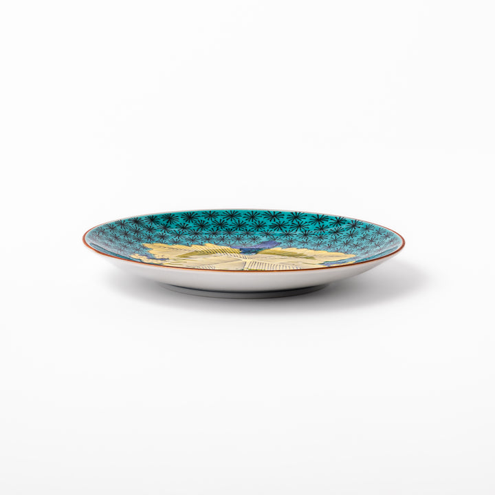 Round Kutani dessert plate with a bold golden leaf and grape motif on a turquoise background patterned with black starbursts.