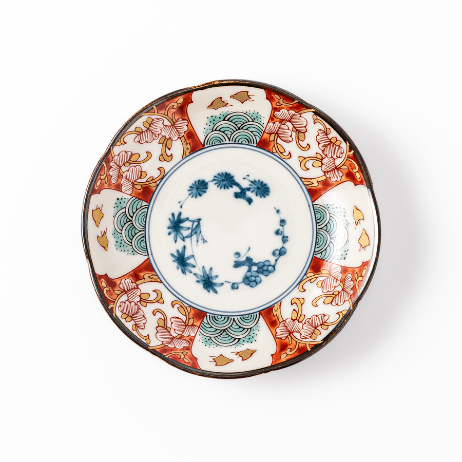 Scalloped edge sauce dish featuring red, blue, and green traditional Japanese motifs with a floral center, perfect for elegant table presentations.
