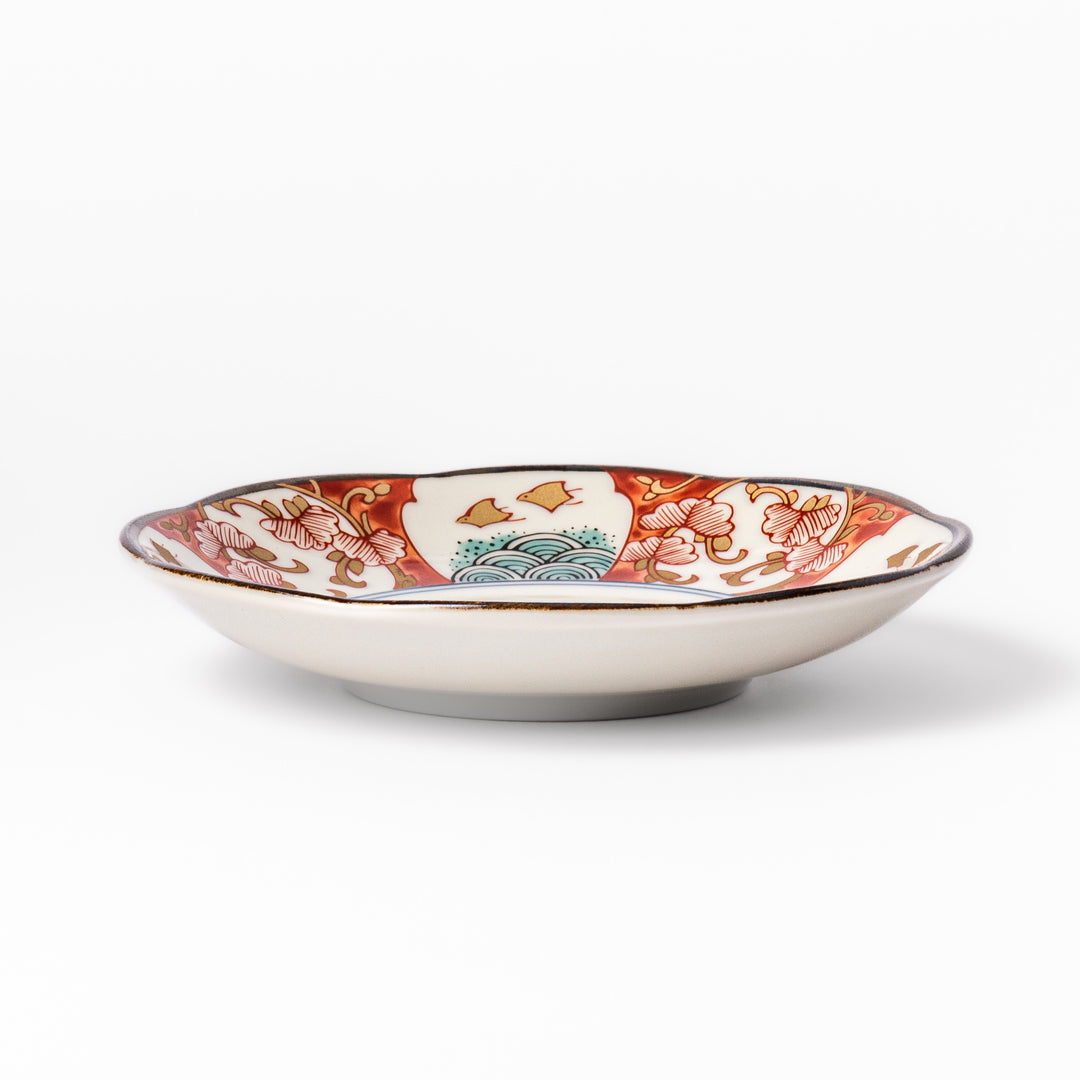 Scalloped edge sauce dish featuring red, blue, and green traditional Japanese motifs with a floral center, perfect for elegant table presentations.