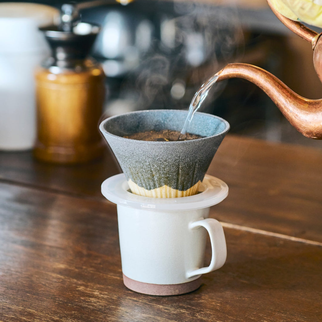 Japanese ceramic coffee filter shaped like Mount Fuji in black and white, used for pour over brewing to highlight traditional craftsmanship.