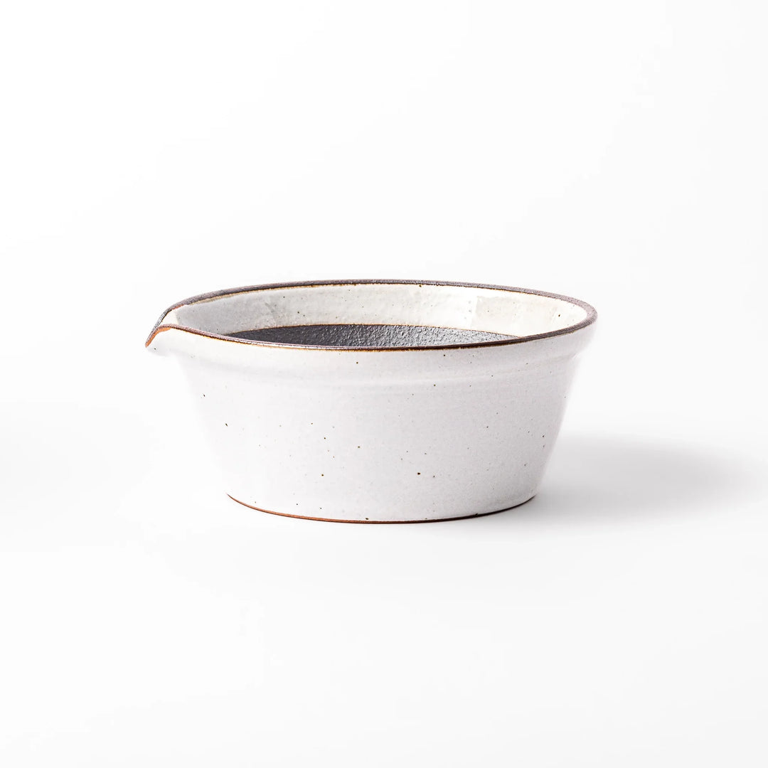 White ceramic suribachi mortar bowl with a smooth dark interior and spout, designed for effortless grinding and elegant table presentation.