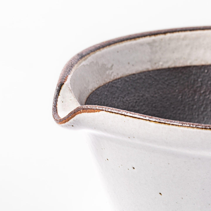 White ceramic suribachi mortar bowl with a smooth dark interior and spout, designed for effortless grinding and elegant table presentation.