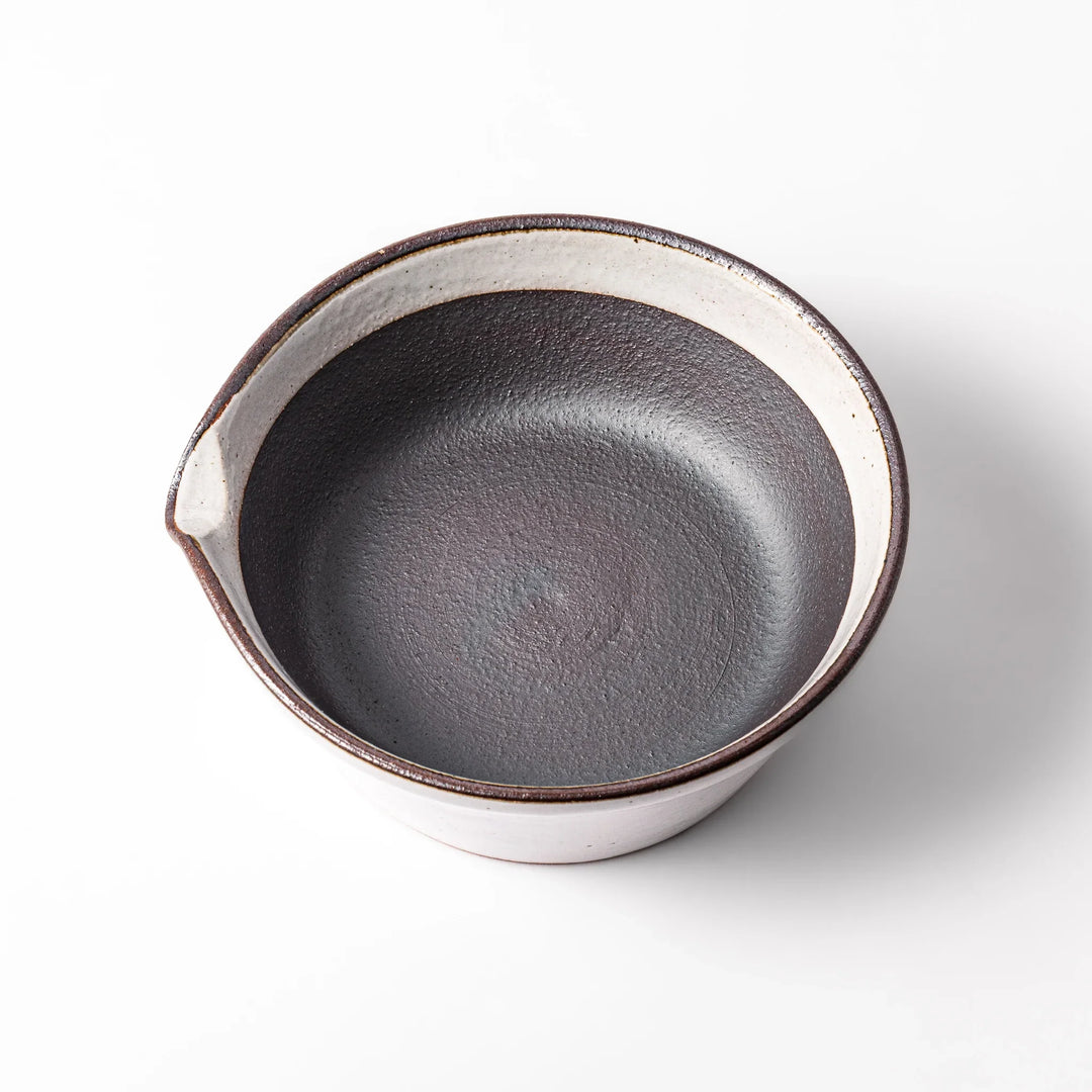 White ceramic suribachi mortar bowl with a smooth dark interior and spout, designed for effortless grinding and elegant table presentation.
