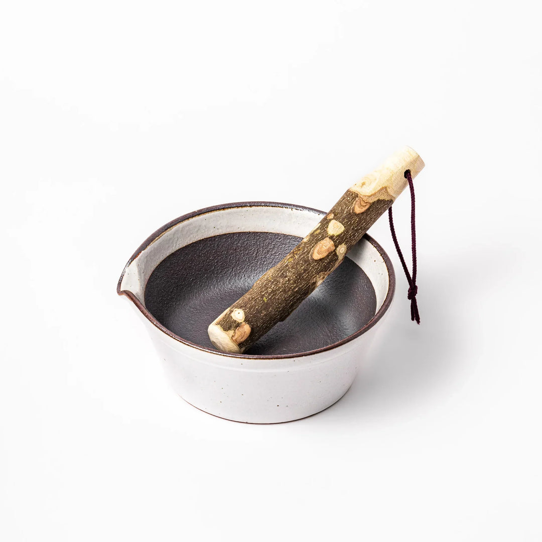 White ceramic suribachi mortar bowl with a smooth dark interior and spout, designed for effortless grinding and elegant table presentation.