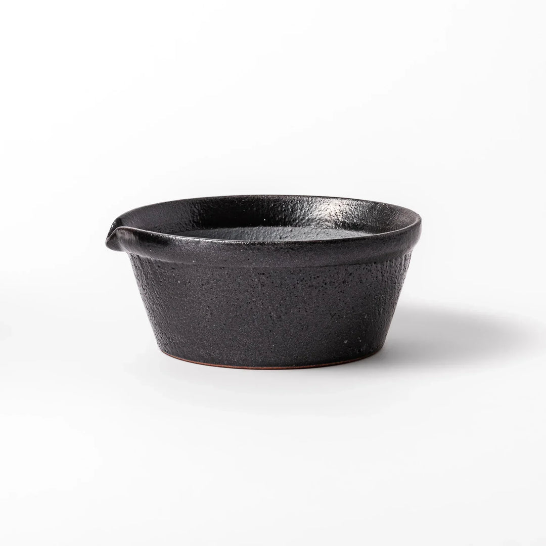 Black ceramic suribachi mortar bowl with a smooth interior and spout, perfect for grinding or mixing without grooves for easy cleanup.