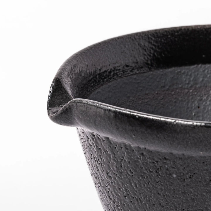 Black ceramic suribachi mortar bowl with a smooth interior and spout, perfect for grinding or mixing without grooves for easy cleanup.