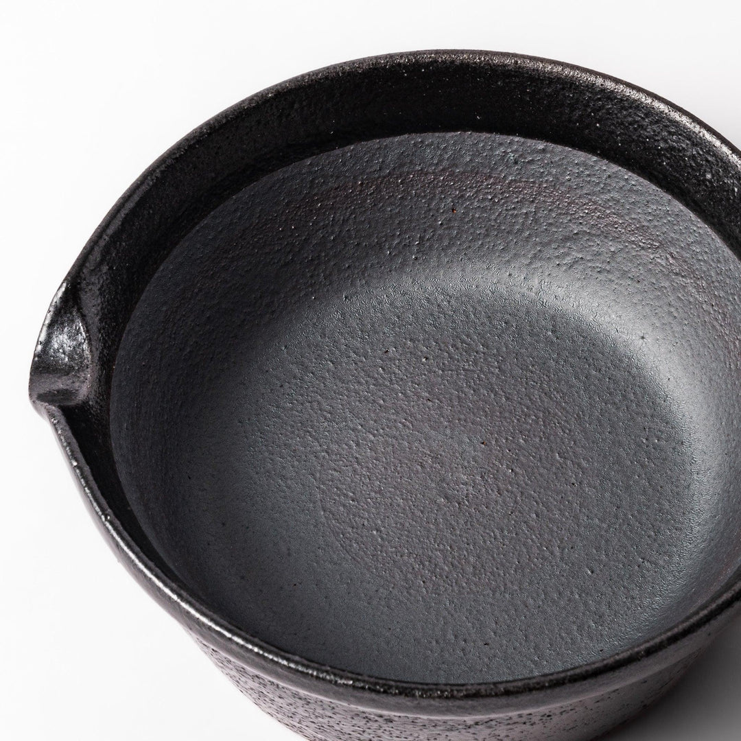Black ceramic suribachi mortar bowl with a smooth interior and spout, perfect for grinding or mixing without grooves for easy cleanup.