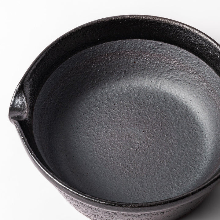 Black ceramic suribachi mortar bowl with a smooth interior and spout, perfect for grinding or mixing without grooves for easy cleanup.