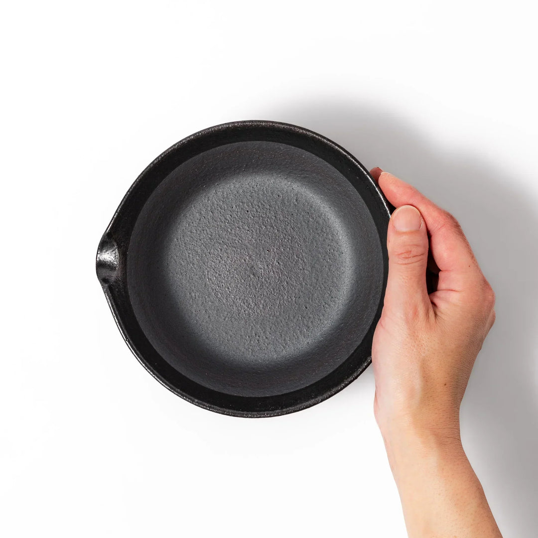 Black ceramic suribachi mortar bowl with a smooth interior and spout, perfect for grinding or mixing without grooves for easy cleanup.