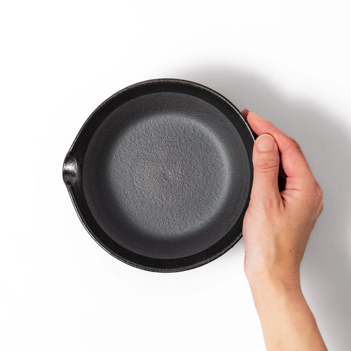 Black ceramic suribachi mortar bowl with a smooth interior and spout, perfect for grinding or mixing without grooves for easy cleanup.