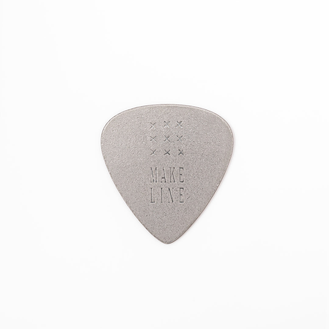 Unique guitar pick shaped metal coaster with sandblasted textured finish engraved with make line text and cross patterns