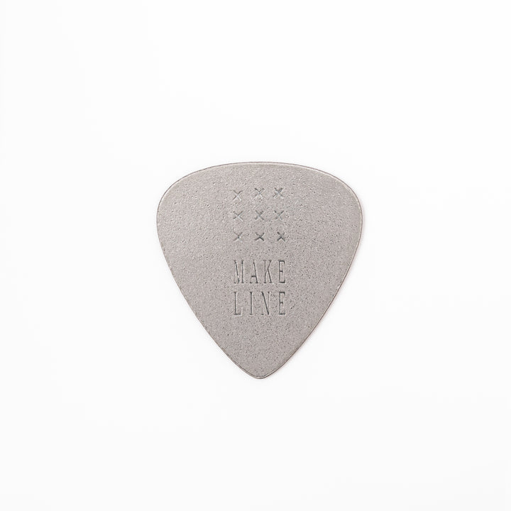 Unique guitar pick shaped metal coaster with sandblasted textured finish engraved with make line text and cross patterns