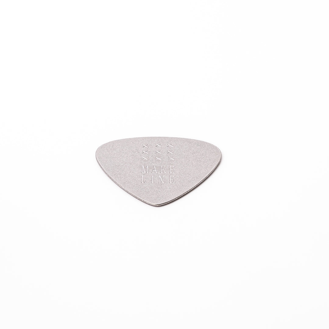 Unique guitar pick shaped metal coaster with sandblasted textured finish engraved with make line text and cross patterns