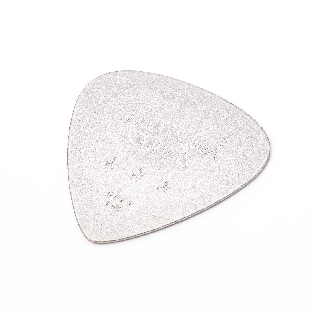 Unique guitar pick shaped metal coaster with sandblasted textured finish engraved with thousand sounds text and stars
