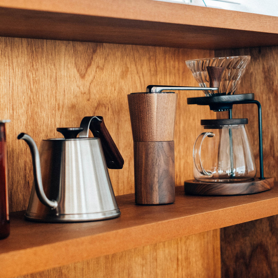 Storing hario walnut wood coffee grinder and stainless kettle on wooden kitchen shelf pour over dripper stand manual mill