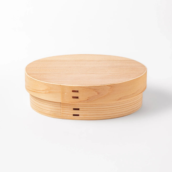 Oval bento box handcrafted from smooth hinoki wood with traditional joinery, offering a lightweight and aromatic way to carry Japanese-style meals.
