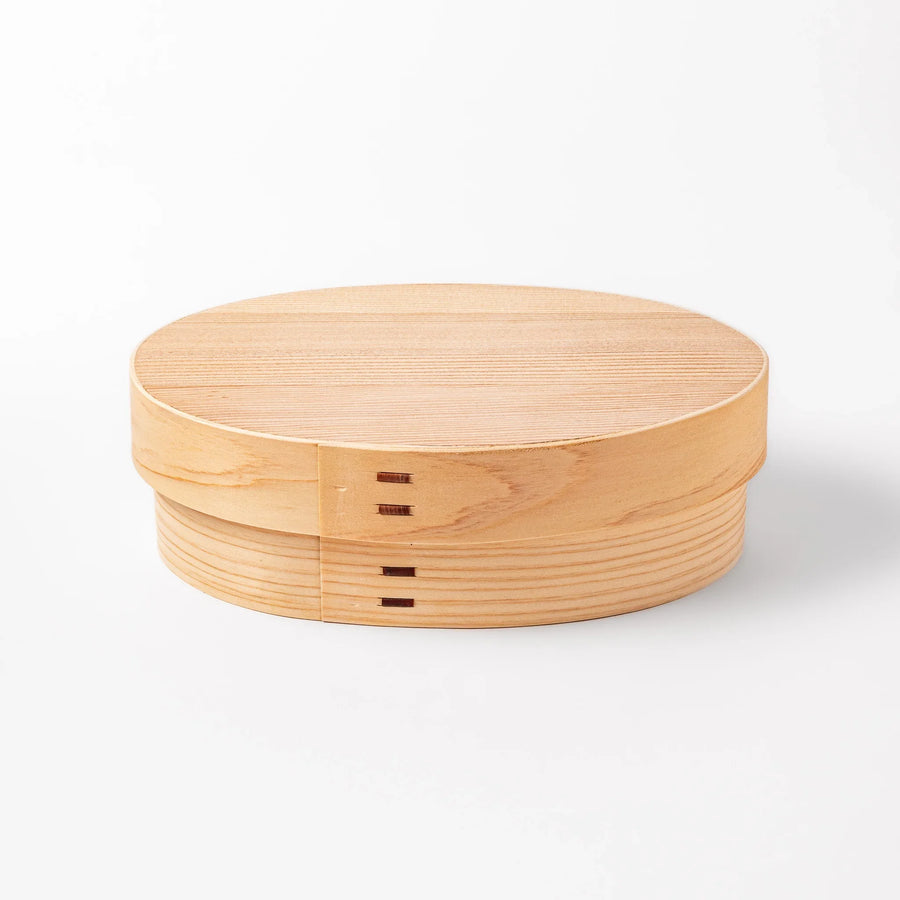 Oval bento box handcrafted from smooth hinoki wood with traditional joinery, offering a lightweight and aromatic way to carry Japanese-style meals.
