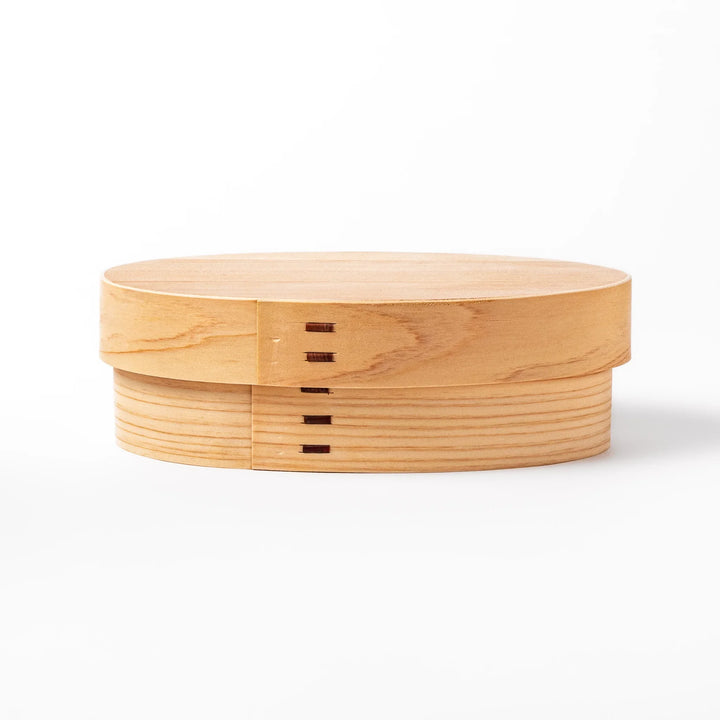 Oval bento box handcrafted from smooth hinoki wood with traditional joinery, offering a lightweight and aromatic way to carry Japanese-style meals.
