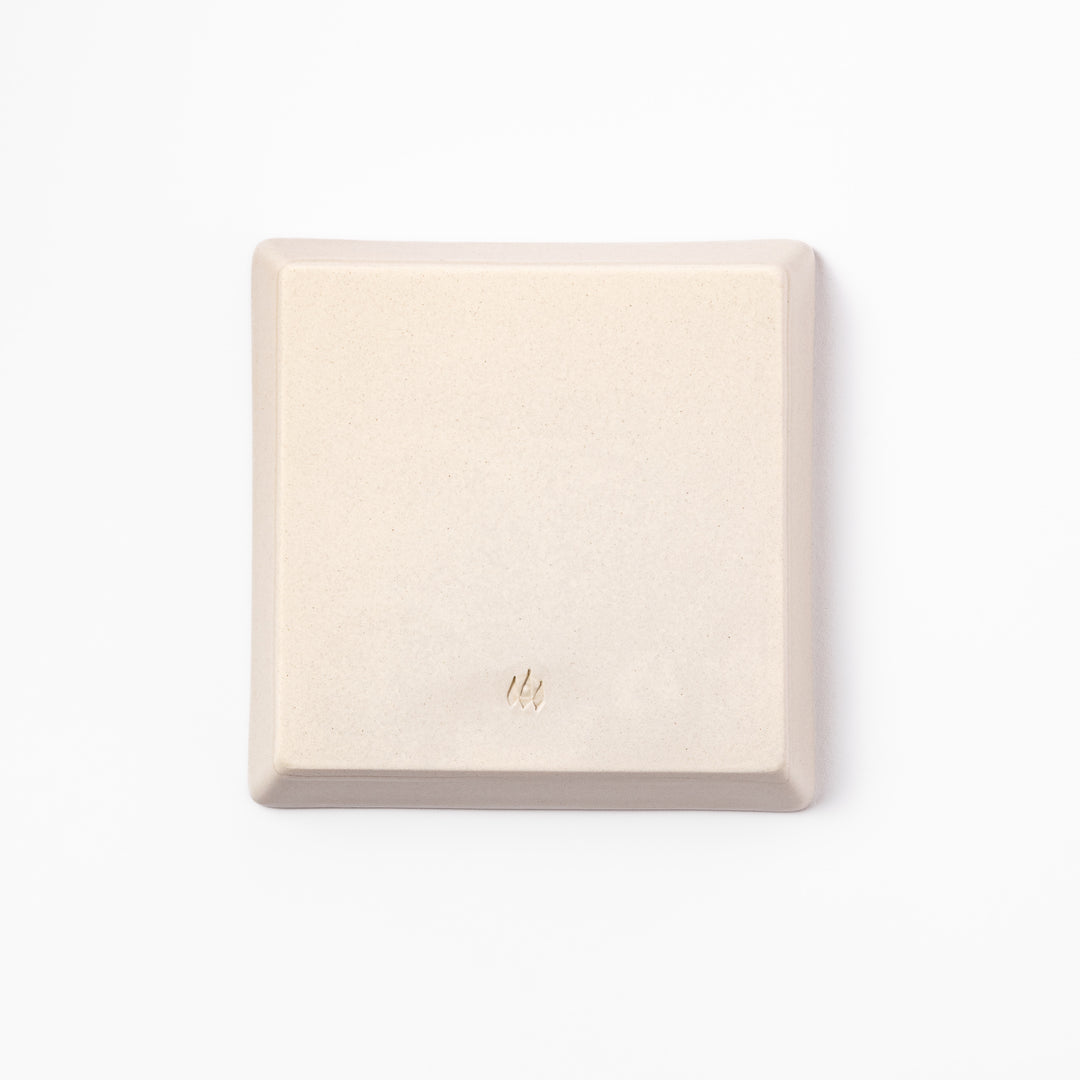 Beige square plate with playful calico cat and butterfly illustration, accented with dotted lines and paw prints.