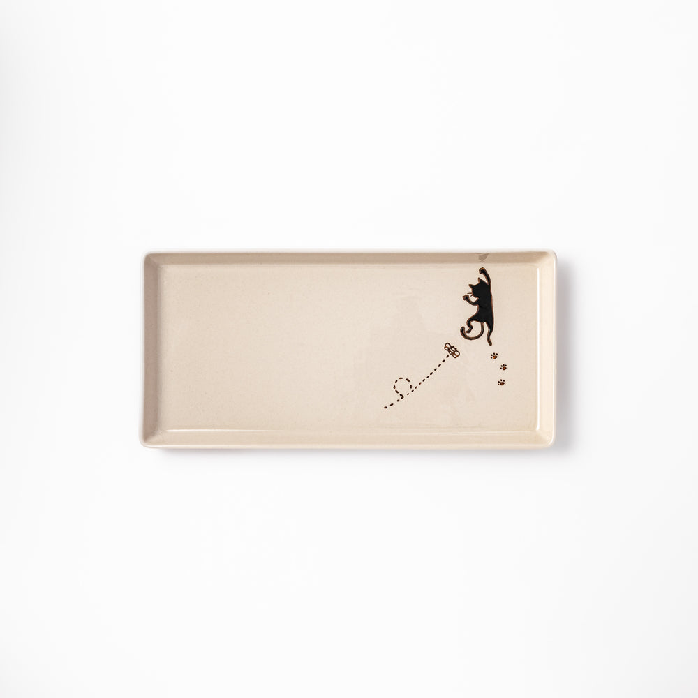 Beige rectangular ceramic plate featuring a playful black cat illustration with paw prints and a butterfly in the corner.