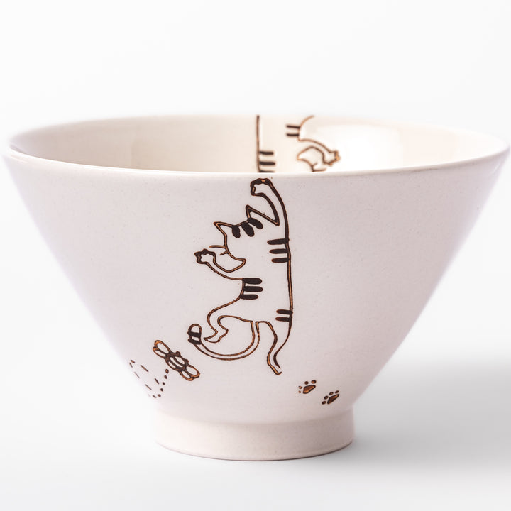 Cream-colored rice bowl with a striped hanging cat, butterfly, and dotted paw prints on the outer and inner surface.