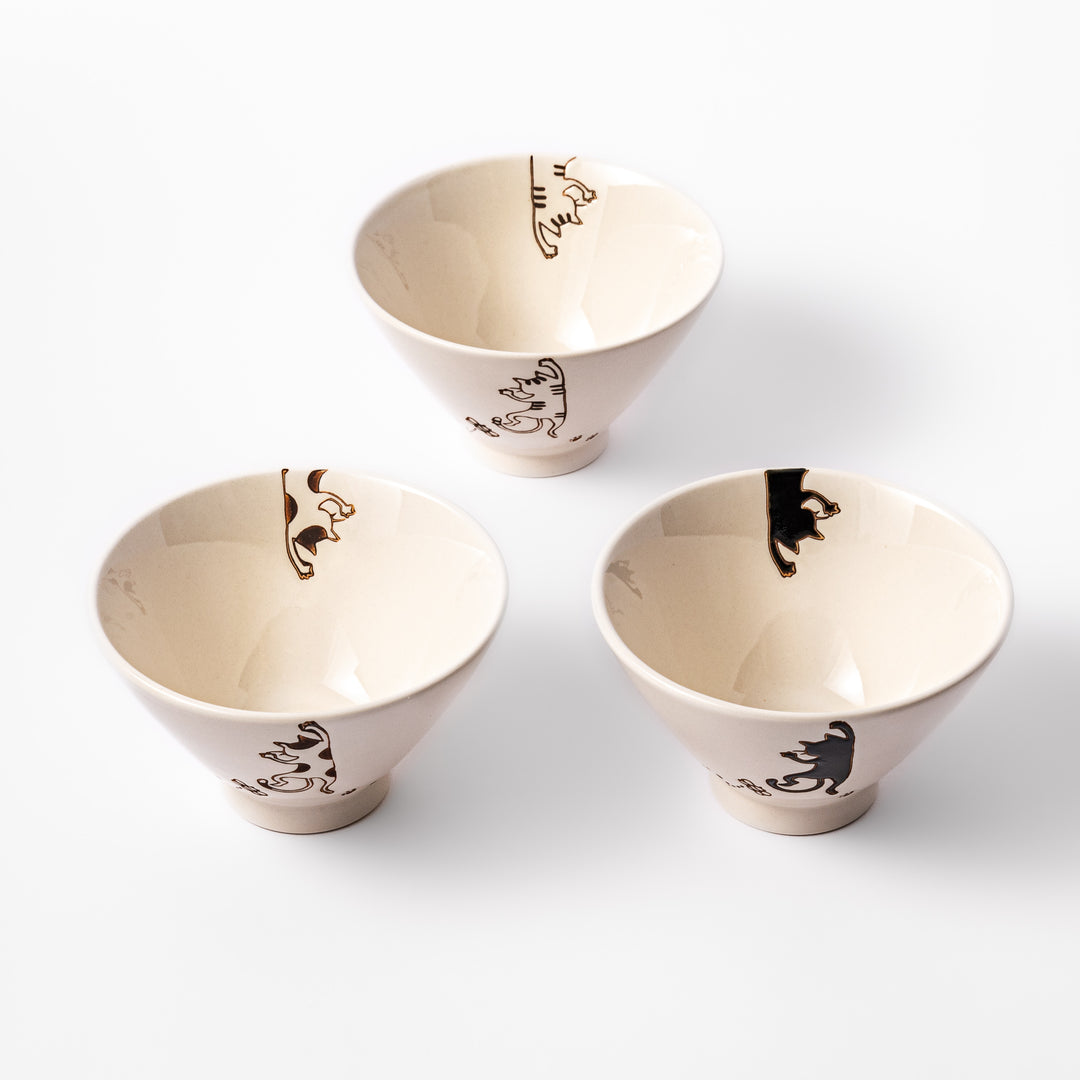 Set of three cream-colored rice bowls with hanging cat designs in black, calico, and tabby, featuring butterflies and paw prints.