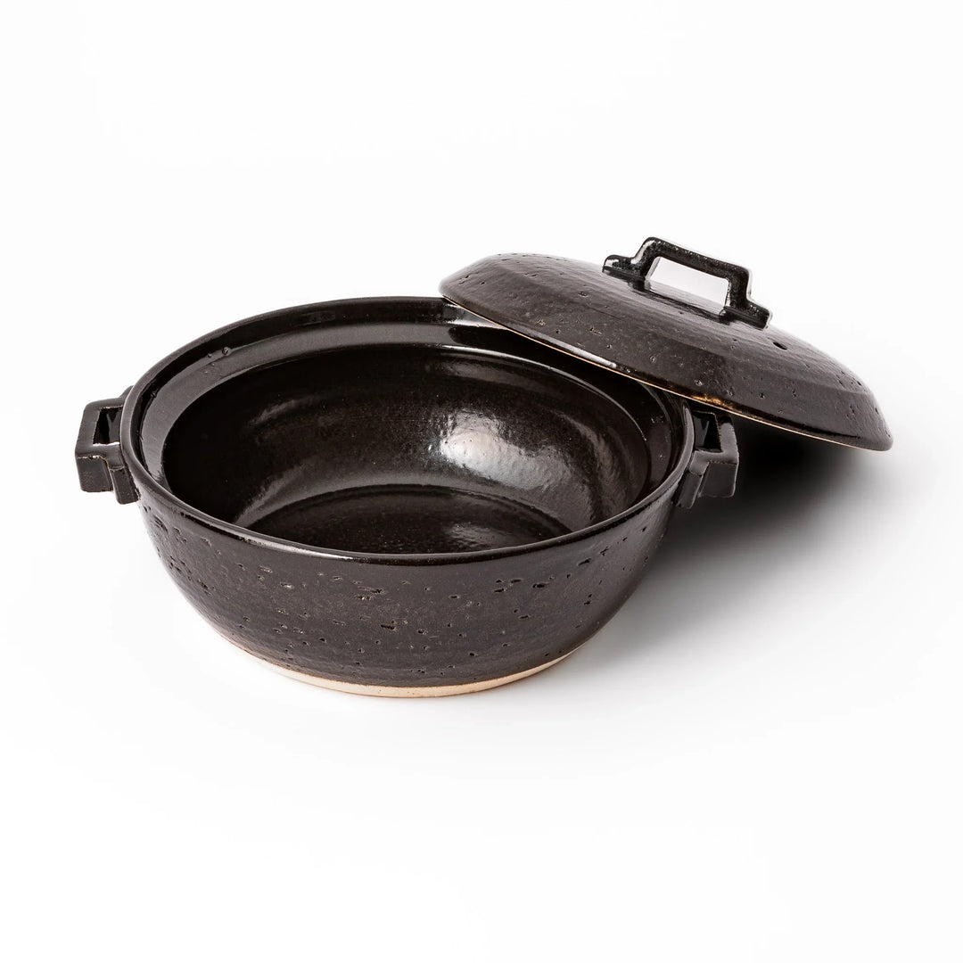 Black Japanese ceramic donabe pot with lid and side handles for simmering and hot pot cooking