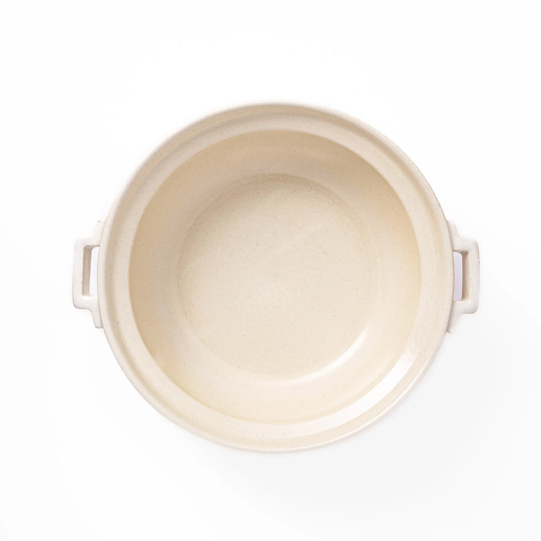 White Japanese donabe with a vented lid and side handles made of rustic handcrafted ceramic