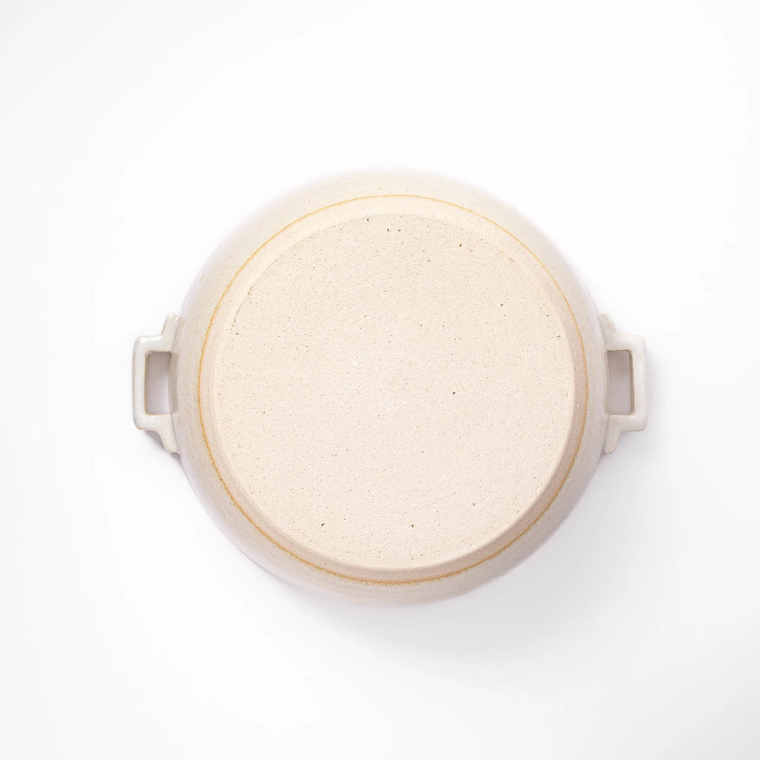 White Japanese donabe with a vented lid and side handles made of rustic handcrafted ceramic