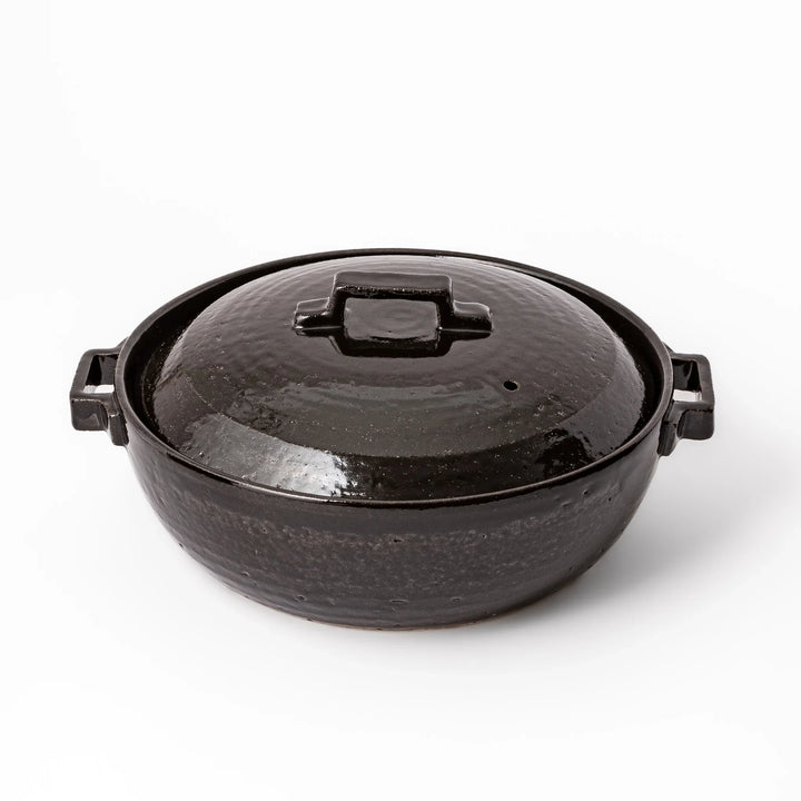 Black Japanese ceramic donabe with a fitted lid and side handles for family size hot pot and stovetop cooking
