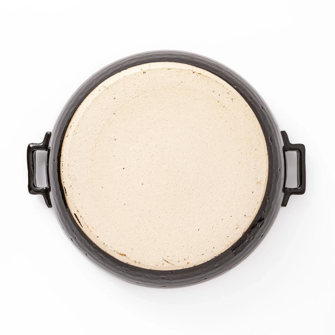 Black Japanese ceramic donabe with a fitted lid and side handles for family size hot pot and stovetop cooking