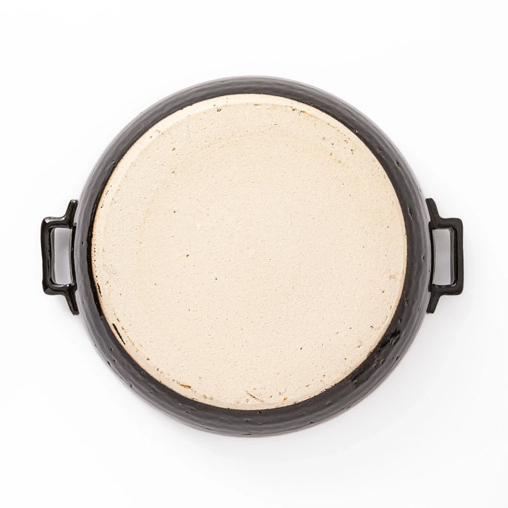 Black Japanese ceramic donabe with a fitted lid and side handles for family size hot pot and stovetop cooking