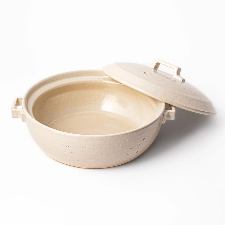 Beige Japanese ceramic family size donabe with a fitted lid and side handles for stovetop cooking and hot pot meals